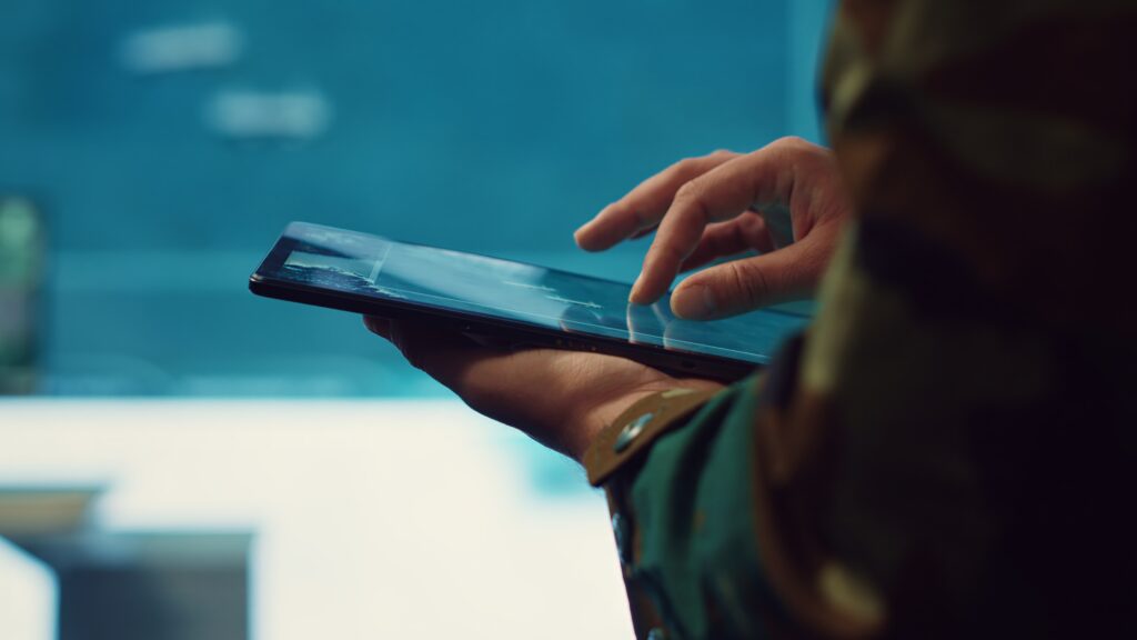 Close-up of a person using a tablet device, highlighting digital forensic services and technology.