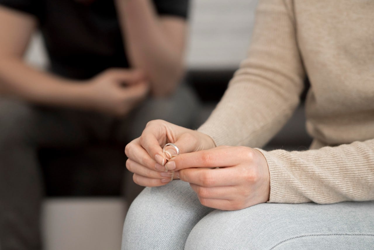 A couple going through a seperation, a female holding a wedding ring